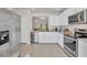 Bright kitchen with stainless appliances and white cabinets looking into the living room at 4324 Knowles Ln, North Port, FL 34288