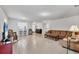 Open concept living room with tile flooring, plush couch, and view to a kitchen area at 4324 Knowles Ln, North Port, FL 34288