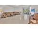 Spacious living room featuring tile flooring, a plush couch, and sliding glass doors to the outside at 4324 Knowles Ln, North Port, FL 34288