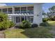 Building exterior with covered lanai, mature landscaping, and manicured lawn at 435 Cerromar Ln # 326, Venice, FL 34293