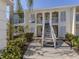 Two-story condo with white exterior, shutters, and a staircase leading to the upper level units at 435 Cerromar Ln # 326, Venice, FL 34293