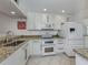 Bright kitchen featuring granite countertops, modern white cabinetry, and stainless steel appliances at 435 Cerromar Ln # 326, Venice, FL 34293