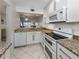Renovated kitchen featuring granite countertops, white appliances, and an open design at 435 Cerromar Ln # 326, Venice, FL 34293