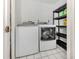 Practical laundry room featuring a washer, dryer, and shelving for storage solutions at 435 Cerromar Ln # 326, Venice, FL 34293