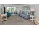 Comfortable living room featuring a blue sofa, a teal armchair, and sliding doors to a balcony with a view at 435 Cerromar Ln # 326, Venice, FL 34293
