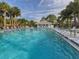 Beautiful community pool featuring ample lounge chairs, shaded umbrellas, and a nearby pool house at 435 Cerromar Ln # 326, Venice, FL 34293