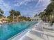 Beautiful community pool featuring ample lounge chairs, shaded umbrellas, and a nearby pool house at 435 Cerromar Ln # 326, Venice, FL 34293