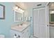 Bright bathroom featuring a white vanity, mirrored cabinet, towel rack, and bifold closet doors at 441 Cerromar # 404, Venice, FL 34293