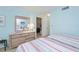 Cozy bedroom featuring two twin beds with red and gray striped bedding, and a dresser with a large mirror at 441 Cerromar # 404, Venice, FL 34293