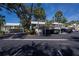 Street-level view showcasing carport parking, lush tropical landscaping, and inviting condo residences under a clear blue sky at 440 Cerromar # 404, Venice, FL 34293