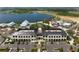 Aerial view of a large complex with a central building, parking, and a picturesque lake in the background at 456 Pinewood Lake Dr, Venice, FL 34285