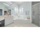 Bright bathroom with a large soaking tub, separate shower, and dual sink vanity at 456 Pinewood Lake Dr, Venice, FL 34285