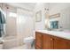 Bright bathroom with shower-tub combo, and wooden vanity cabinet at 456 Pinewood Lake Dr, Venice, FL 34285