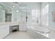 Bright bathroom with a large soaking tub, plantation shutters, and dual sink vanity at 456 Pinewood Lake Dr, Venice, FL 34285