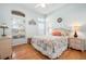 Cozy bedroom features natural light, wood floors, and wicker furniture accents at 456 Pinewood Lake Dr, Venice, FL 34285