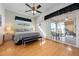 Primary bedroom features a ceiling fan, laminate floors, and sliding door leading to patio at 456 Pinewood Lake Dr, Venice, FL 34285