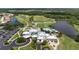 Aerial view of the clubhouse showcasing a golf course, pool, and lake views at 456 Pinewood Lake Dr, Venice, FL 34285