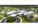 Aerial view of clubhouse featuring a pool, golf course, and lakefront view at 456 Pinewood Lake Dr, Venice, FL 34285