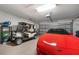 Spacious garage featuring a golf cart and a red sports car on an epoxy floor at 456 Pinewood Lake Dr, Venice, FL 34285