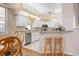 Bright eat-in kitchen with white cabinets, stainless steel appliances, and bar seating at 456 Pinewood Lake Dr, Venice, FL 34285