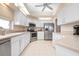 Well-lit kitchen featuring stainless steel appliances, tiled floors, and ample cabinet space at 456 Pinewood Lake Dr, Venice, FL 34285