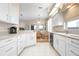 Bright kitchen with white cabinets, stainless steel appliances, and eat-in breakfast nook at 456 Pinewood Lake Dr, Venice, FL 34285