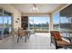 Enclosed lanai with ceiling fan, dining set and seating with a tranquil water view at 456 Pinewood Lake Dr, Venice, FL 34285