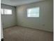 Bedroom featuring two windows, carpeted floors, and neutral walls at 460 Base E Ave # 129, Venice, FL 34285