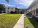 The building's exterior features well-maintained landscaping and a long walkway to the units at 460 Base E Ave # 129, Venice, FL 34285