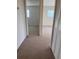 Neutral-colored hallway with carpet and doors leading to bedrooms at 460 Base E Ave # 129, Venice, FL 34285