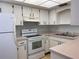 A well-maintained kitchen with white cabinets, countertops, and appliances at 460 Base E Ave # 129, Venice, FL 34285