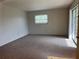 A bright living room featuring neutral carpet, walls, and a sliding glass door to the patio at 460 Base E Ave # 129, Venice, FL 34285