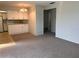 Open-concept living area featuring carpet, white walls, and access to the kitchen at 460 Base E Ave # 129, Venice, FL 34285