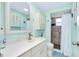 Inviting bathroom with white vanity, cabinet storage, accent mirror, and walk-in shower at 483 Circlewood Dr # O14, Venice, FL 34293