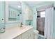 Stylish bathroom with a white vanity, storage cabinet, and walk-in shower with decorative accents at 483 Circlewood Dr # O14, Venice, FL 34293