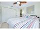 Cozy bedroom with striped bedding, an anchor pillow, and view to the kitchen through the doorway at 483 Circlewood Dr # O14, Venice, FL 34293