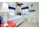 Comfortable bedroom with a coastal design, ceiling fan, and two windows with blue valances at 483 Circlewood Dr # O14, Venice, FL 34293