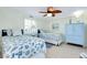 Bright bedroom with two beds, beach themed decor, light wood floors, and ceiling fan at 483 Circlewood Dr # O14, Venice, FL 34293