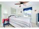 Comfortable bedroom features coastal decor, a ceiling fan, and a bright window to the outside at 483 Circlewood Dr # O14, Venice, FL 34293