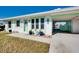 Inviting home with vibrant turquoise accents, well-manicured landscaping, and a convenient carport at 483 Circlewood Dr # O14, Venice, FL 34293