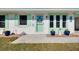 Charming home featuring a welcoming front entrance with a vibrant turquoise door and seaside decor at 483 Circlewood Dr # O14, Venice, FL 34293