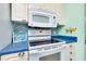 The kitchen features white appliances and cabinets, mosaic tile backsplash and blue countertop at 483 Circlewood Dr # O14, Venice, FL 34293