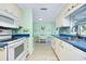 Bright kitchen featuring white cabinetry, blue countertops, and a cozy breakfast nook with tiled backsplash at 483 Circlewood Dr # O14, Venice, FL 34293