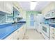 Bright kitchen featuring white appliances, blue countertops, tile backsplash, and convenient access to the lanai at 483 Circlewood Dr # O14, Venice, FL 34293
