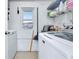 Functional laundry room with modern washer and dryer, shelving, and natural light from the window at 483 Circlewood Dr # O14, Venice, FL 34293