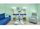 Bright living room featuring a blue sofa, coastal decor, and an airy, beach-inspired design at 483 Circlewood Dr # O14, Venice, FL 34293