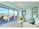 Relaxing sunroom with sliding glass doors to patio, neutral furniture, and serene waterfront view at 483 Circlewood Dr # O14, Venice, FL 34293