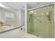 Bathroom showcasing a glass-enclosed shower, granite vanity, and white tile floors and fixtures at 49 Sandstone Cir, Venice, FL 34293