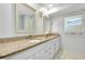 Bathroom featuring a double vanity with granite countertops, white cabinets, and modern fixtures at 49 Sandstone Cir, Venice, FL 34293