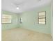 Serene bedroom with neutral carpet, multiple windows, and a ceiling fan at 49 Sandstone Cir, Venice, FL 34293